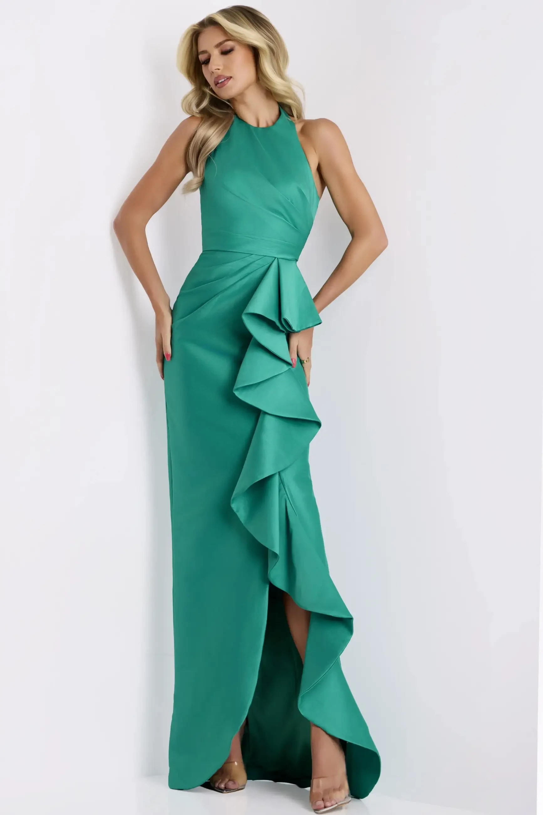 A woman wearing a long, green dress with ruffled details on one side.