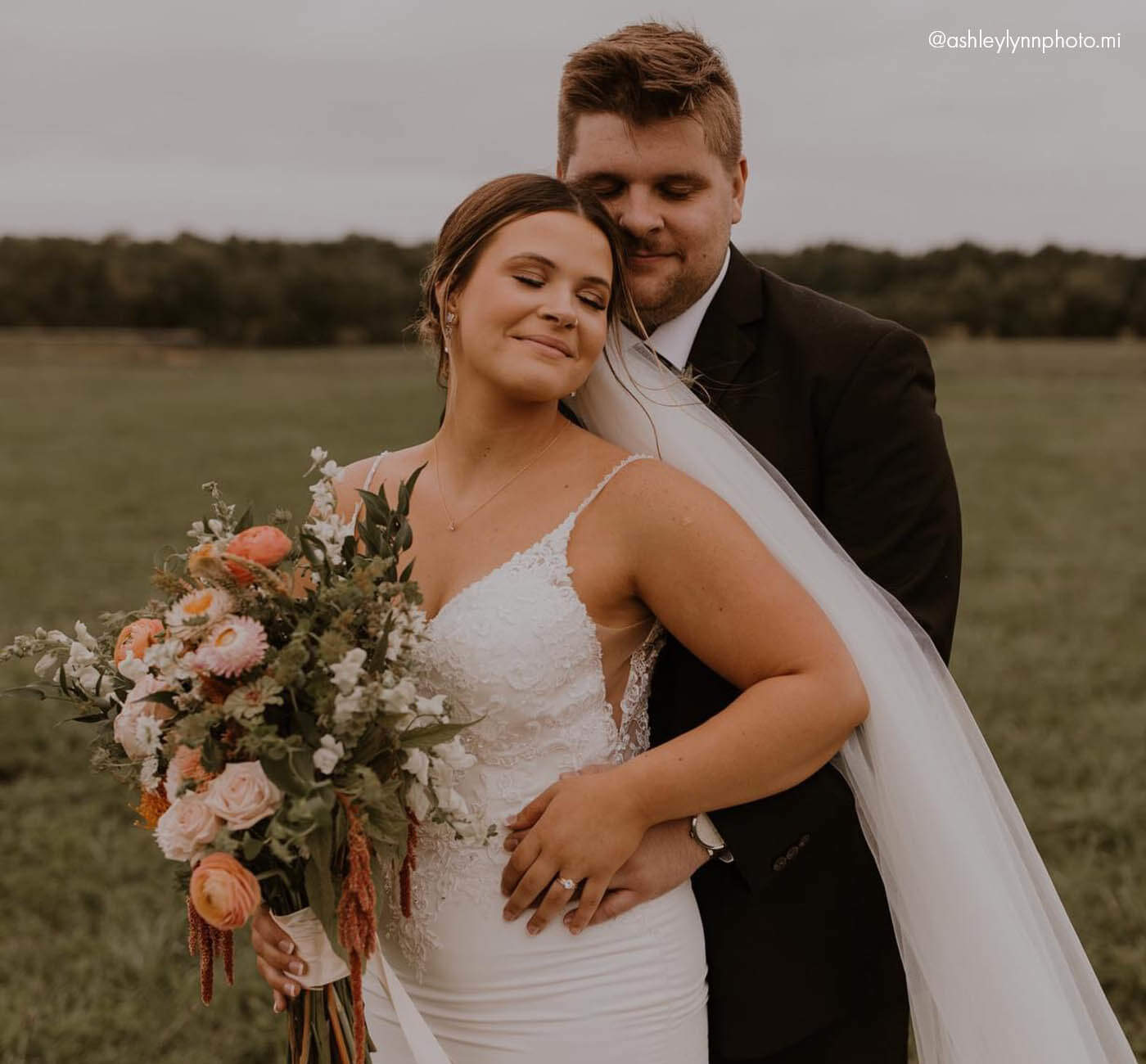 Сouple wearing a white gown with and a brown suit